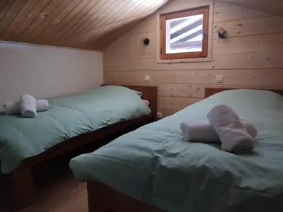 a bedroom with two beds in a wooden cabin at Chalet-Hôtel de l'Etape in Les Contamines-Montjoie