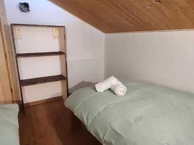 a small bedroom with a bed and a book shelf at Chalet-Hôtel de l'Etape in Les Contamines-Montjoie