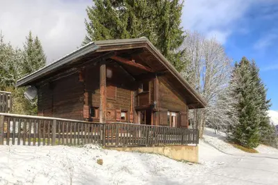 a log cabin with a fence in the snow at Chalet-Hôtel de l'Etape in Les Contamines-Montjoie