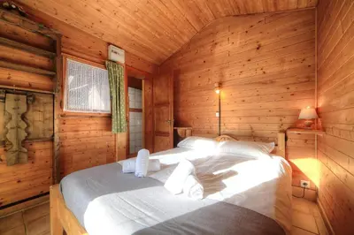 a bedroom with a bed in a wooden cabin at Chalet-Hôtel de l'Etape in Les Contamines-Montjoie