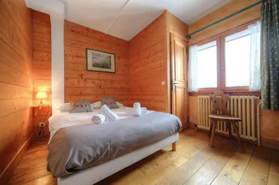 a bedroom with wooden walls and a bed in a room at Chalet-Hôtel de l'Etape in Les Contamines-Montjoie