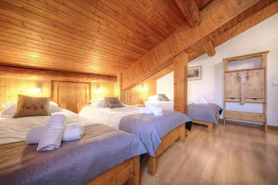 a bedroom with two beds and a wooden ceiling at Chalet-Hôtel de l'Etape in Les Contamines-Montjoie