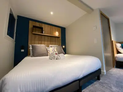 a bedroom with a large white bed with a headboard at Chalet Pleine Vue & Spa in Chamonix-Mont-Blanc