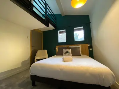a bedroom with a large white bed with a green wall at Chalet Pleine Vue & Spa in Chamonix-Mont-Blanc