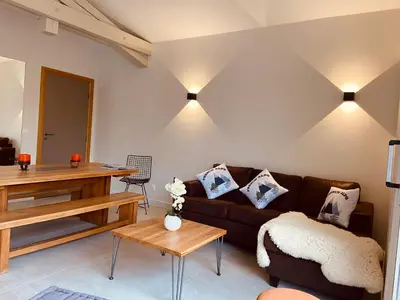 a living room with a couch and a table at Chalet Pleine Vue & Spa in Chamonix-Mont-Blanc