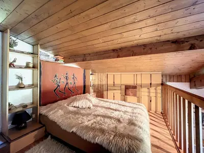 a bedroom with a bed in a room with wooden walls at Duplex cosy au pied des pistes de Combloux - FR-1-560-47 in Combloux