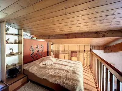 a bed in a room with a wooden ceiling at Duplex cosy au pied des pistes de Combloux - FR-1-560-47 in Combloux