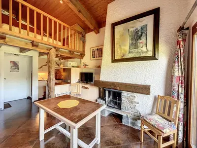 a dining room with a table and a fireplace at Duplex cosy au pied des pistes de Combloux - FR-1-560-47 in Combloux