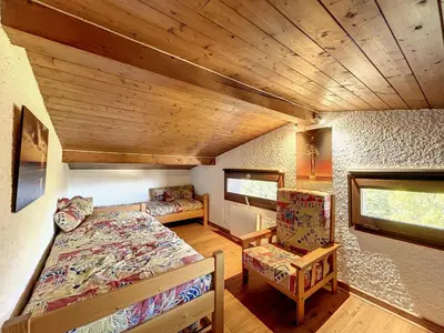 a bedroom with a bed and a chair in a room at Duplex cosy au pied des pistes de Combloux - FR-1-560-47 in Combloux