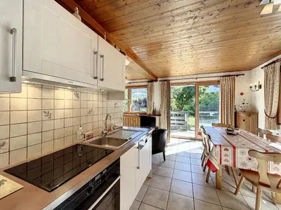 a kitchen with a sink and a table at Bel Apt au Centre de Combloux avec Jardin, Balcon, Wifi et Parking à 300m des Commerces - FR-1-560-52 in Combloux