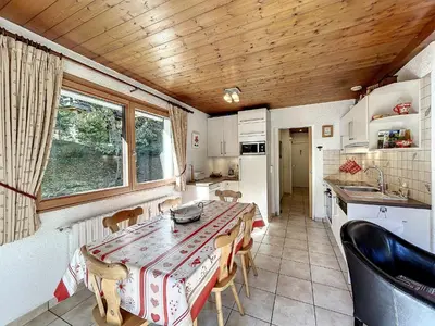 a kitchen with a table and chairs in a kitchen at Bel Apt au Centre de Combloux avec Jardin, Balcon, Wifi et Parking à 300m des Commerces - FR-1-560-52 in Combloux