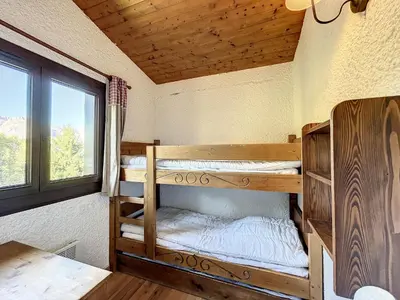 two bunk beds in a room with a window at Charmant 3 pièces au pied des pistes à Combloux - FR-1-560-59 in Combloux