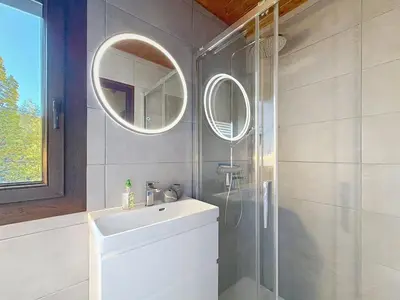 a bathroom with a sink and a shower with a mirror at Charmant 3 pièces au pied des pistes à Combloux - FR-1-560-59 in Combloux