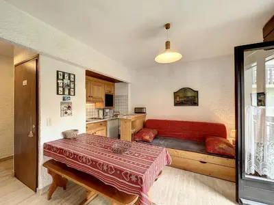 a living room with a red couch and a kitchen at Appartement cosy au pied des pistes à Combloux avec balcon et casier à skis - FR-1-560-61 in Combloux