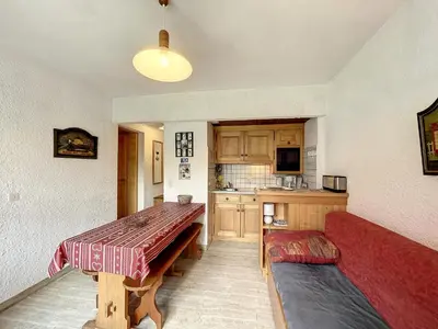 a kitchen with a table and a couch in a room at Appartement cosy au pied des pistes à Combloux avec balcon et casier à skis - FR-1-560-61 in Combloux