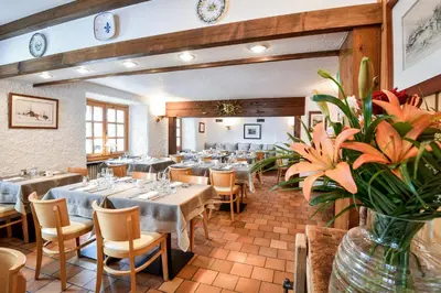 a restaurant with tables and chairs and a vase of flowers at Chalet-hôtel Gai Soleil in Les Contamines-Montjoie
