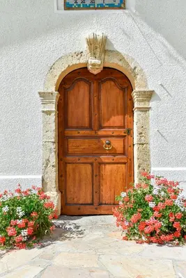 a wooden door with flowers in front of a building at Chalet-hôtel Gai Soleil in Les Contamines-Montjoie