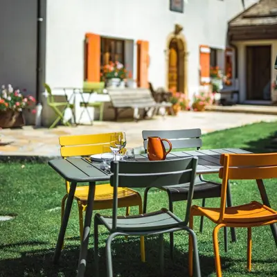 a table and chairs sitting on the grass in a yard at Chalet-hôtel Gai Soleil in Les Contamines-Montjoie