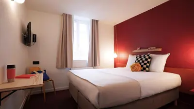 a bedroom with a large bed with a red wall at PlanB - Living Saint-Gervais - 250m des Remontées Mécaniques in Saint-Gervais-les-Bains