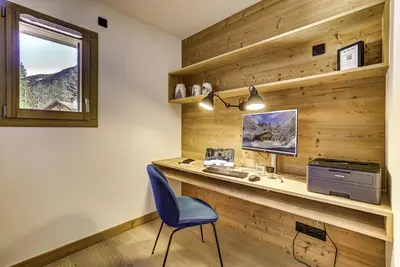 a desk with a computer and a blue chair at Residence Le Green in Chamonix-Mont-Blanc
