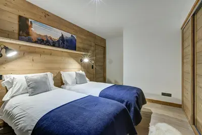 two beds in a hotel room with blue and white sheets at Residence Le Green in Chamonix-Mont-Blanc