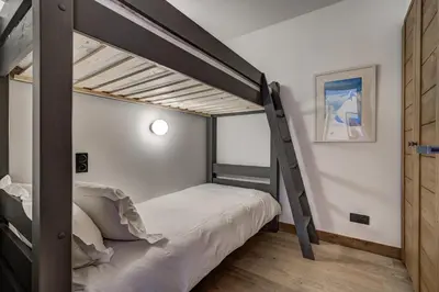 a bedroom with a bunk bed with a ladder at Residence Le Green in Chamonix-Mont-Blanc