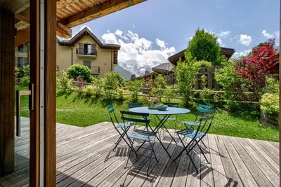 a patio with a table and chairs on a deck at Residence Le Green in Chamonix-Mont-Blanc