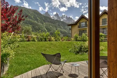 a chair sitting on a deck with a view of a yard at Residence Le Green in Chamonix-Mont-Blanc