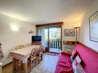 a living room with a table and a red couch at Studio cabine proche centre Combloux, 4 pers, balcon, parking - FR-1-560-53 in Combloux