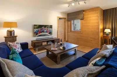 a living room with a blue couch and a table at Coin des Drus Apartment - Chamonix All Year in Chamonix-Mont-Blanc