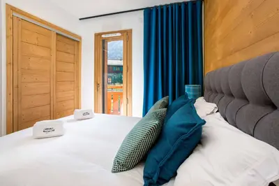 a bedroom with a bed with two pillows on it at Coin des Drus Apartment - Chamonix All Year in Chamonix-Mont-Blanc