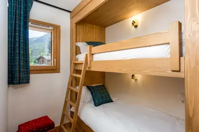 a bedroom with two bunk beds and a window at Coin des Drus Apartment - Chamonix All Year in Chamonix-Mont-Blanc