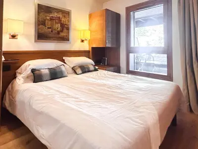 a bedroom with a large white bed with two pillows at 2 Bed Ski in and Ski out Luxury Apt in 5 star Residence in Flaine