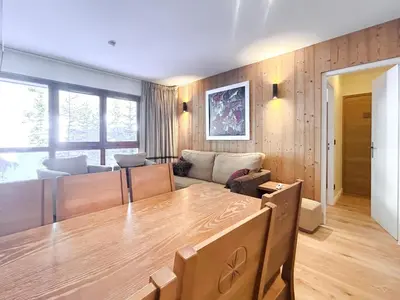 a living room with a table and a couch at 2 Bed Ski in and Ski out Luxury Apt in 5 star Residence in Flaine