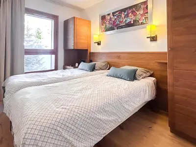 a bedroom with two beds and a window at 2 Bed Ski in and Ski out Luxury Apt in 5 star Residence in Flaine