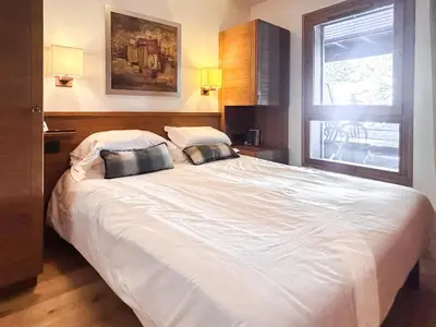 a bedroom with a large white bed with two pillows at 2 Bed Ski in and Ski out Luxury Apt in 5 star Residence in Flaine