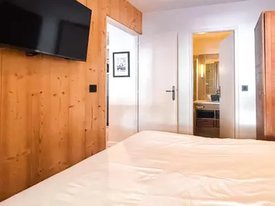 a bedroom with a bed and a flat screen tv at 2 Bed Ski in and Ski out Luxury Apt in 5 star Residence in Flaine