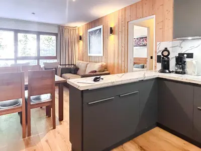 a kitchen and living room with a counter and a table at 2 Bed Ski in and Ski out Luxury Apt in 5 star Residence in Flaine