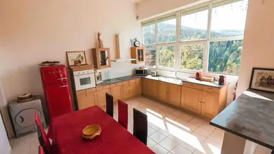 a kitchen with a table and a red refrigerator at Gite74, GLMB à 3 min de l'ascenseur des Thermes in Saint-Gervais-les-Bains