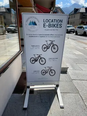 a sign for a bike shop on a sidewalk at Gite74, GLMB à 3 min de l'ascenseur des Thermes in Saint-Gervais-les-Bains