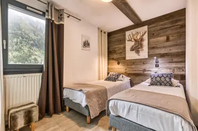 two beds in a room with a window at Alta Rocca in Chamonix-Mont-Blanc
