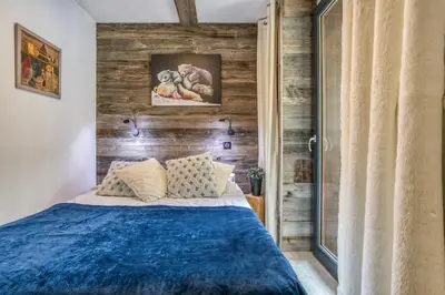 a bedroom with a blue bed and a wooden wall at Alta Rocca in Chamonix-Mont-Blanc