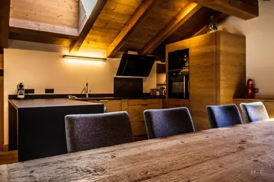 a kitchen with a table and some blue chairs at Ski in ski out Le Moulin charming duplex just 50 m from Princesse gondola Megève in Demi-Quartier