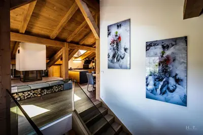 a staircase in a house with two paintings on the wall at Ski in ski out Le Moulin charming duplex just 50 m from Princesse gondola Megève in Demi-Quartier