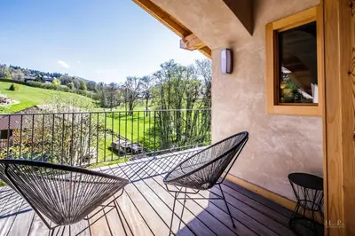 a balcony with two chairs and a view of a yard at Ski in ski out Le Moulin charming duplex just 50 m from Princesse gondola Megève in Demi-Quartier
