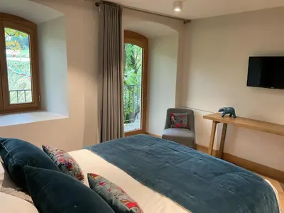a bedroom with a bed and a tv and a chair at Ski in ski out Le Moulin charming duplex just 50 m from Princesse gondola Megève in Demi-Quartier