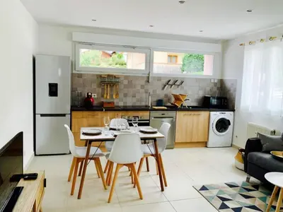 a kitchen and living room with a table and chairs at LE 