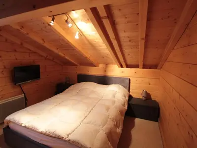 a bedroom with a bed in a wooden room at Chalet 3 chambres 8 pers avec cheminée et parking à 1000m des pistes - FR-1-572-49 in Les Carroz d'Araches