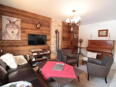 a living room with a couch and a television at Appartement 3 chambres, 2 sdb, parking, proche pistes, équipements de standing - FR-1-572-46 in Les Carroz d'Araches