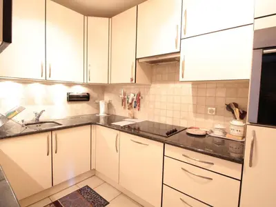 a kitchen with white cabinets and a black counter top at Appartement 3 chambres, 2 sdb, parking, proche pistes, équipements de standing - FR-1-572-46 in Les Carroz d'Araches